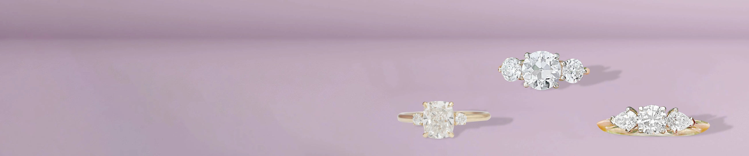 Elegant multi-stone gold diamond rings resting on light lavender setting