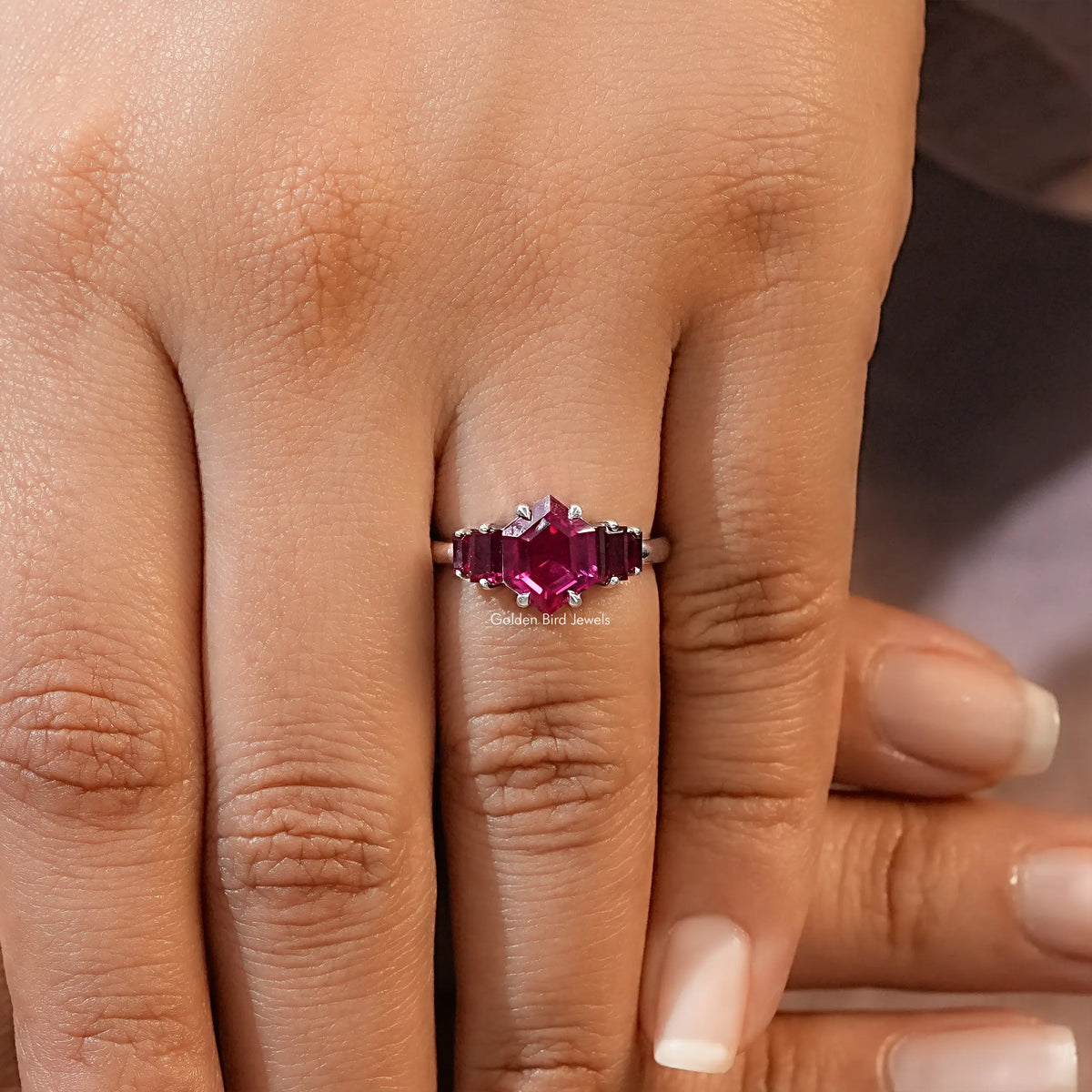 Five-stone ruby red gemstone ring with hexagon-cut center and prong-set side stones