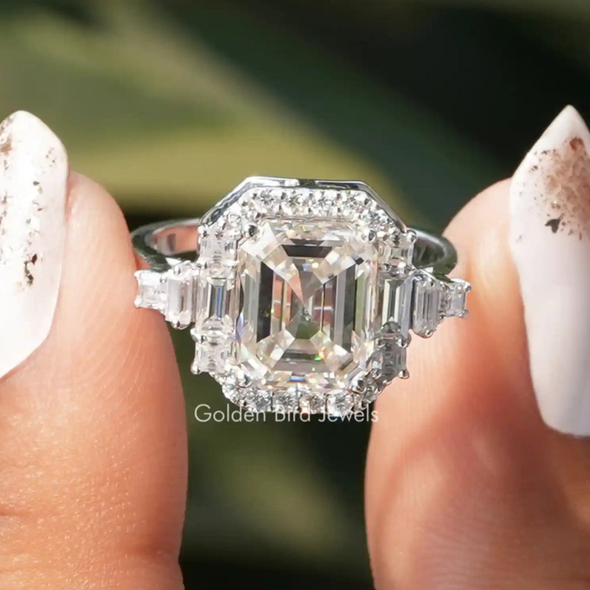 Two fingers holding the Moissanite Asscher Cut Halo Ring