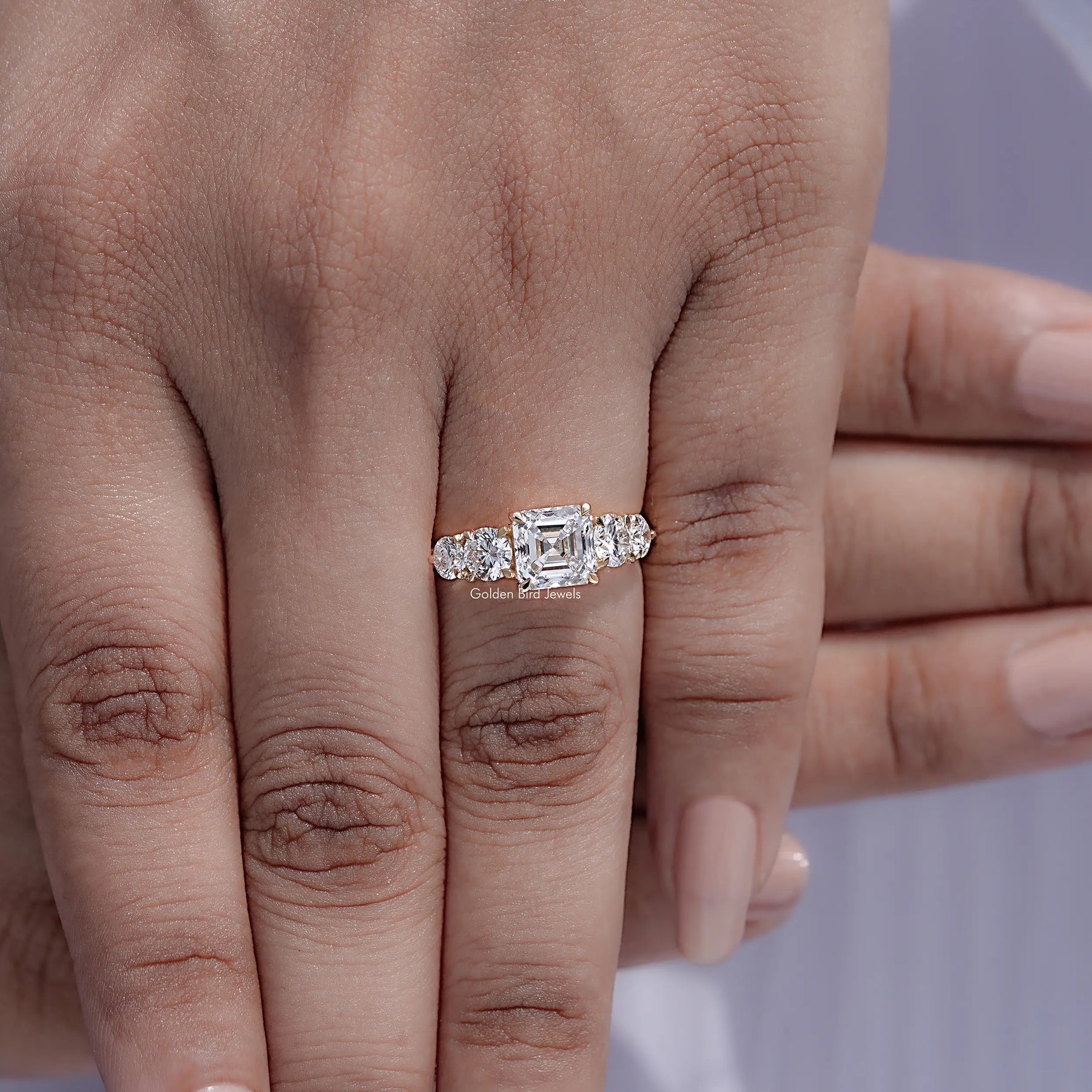 Top view of Asscher Cut Lab Diamond Five Stone Ring Held in Finger