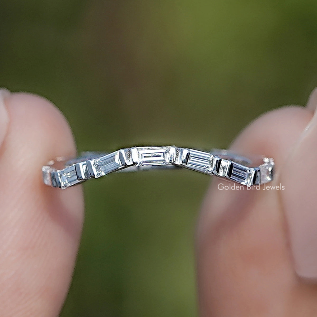 Baguette Shape Lab Grown Diamond Eternity Ring Held Between Fingers