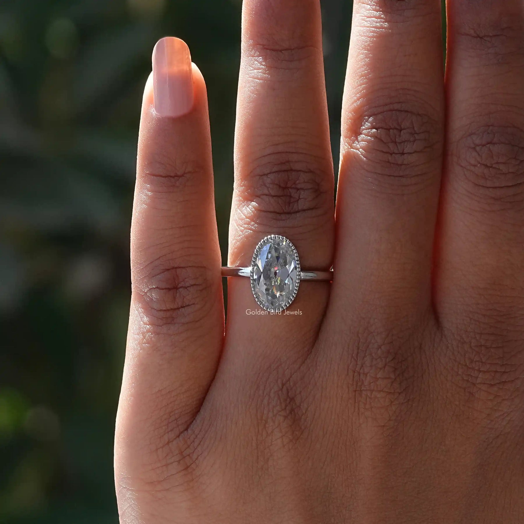 Close-Up View of Bezel Set Oval Cut Moissanite Ring In White Gold