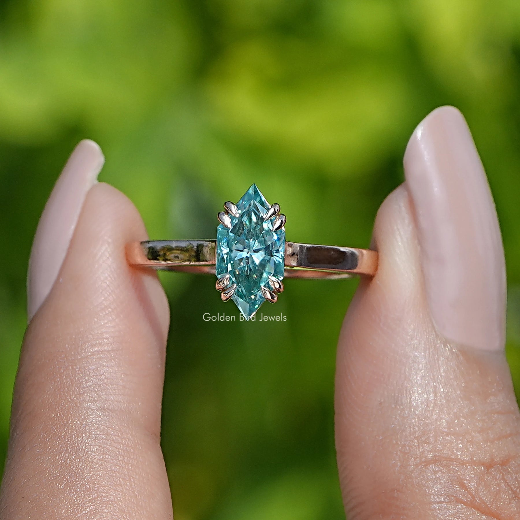 Two fingers holding the Dutch Marquise Cut Moissanite Ring