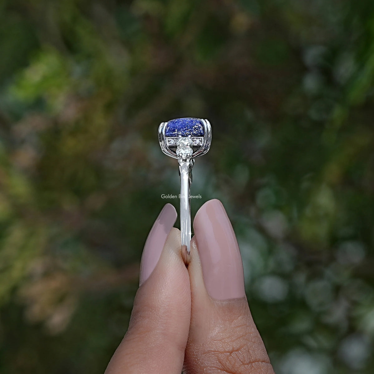 Side View of Emerald Cut Hidden Halo Accent Stone Ring In two fingers