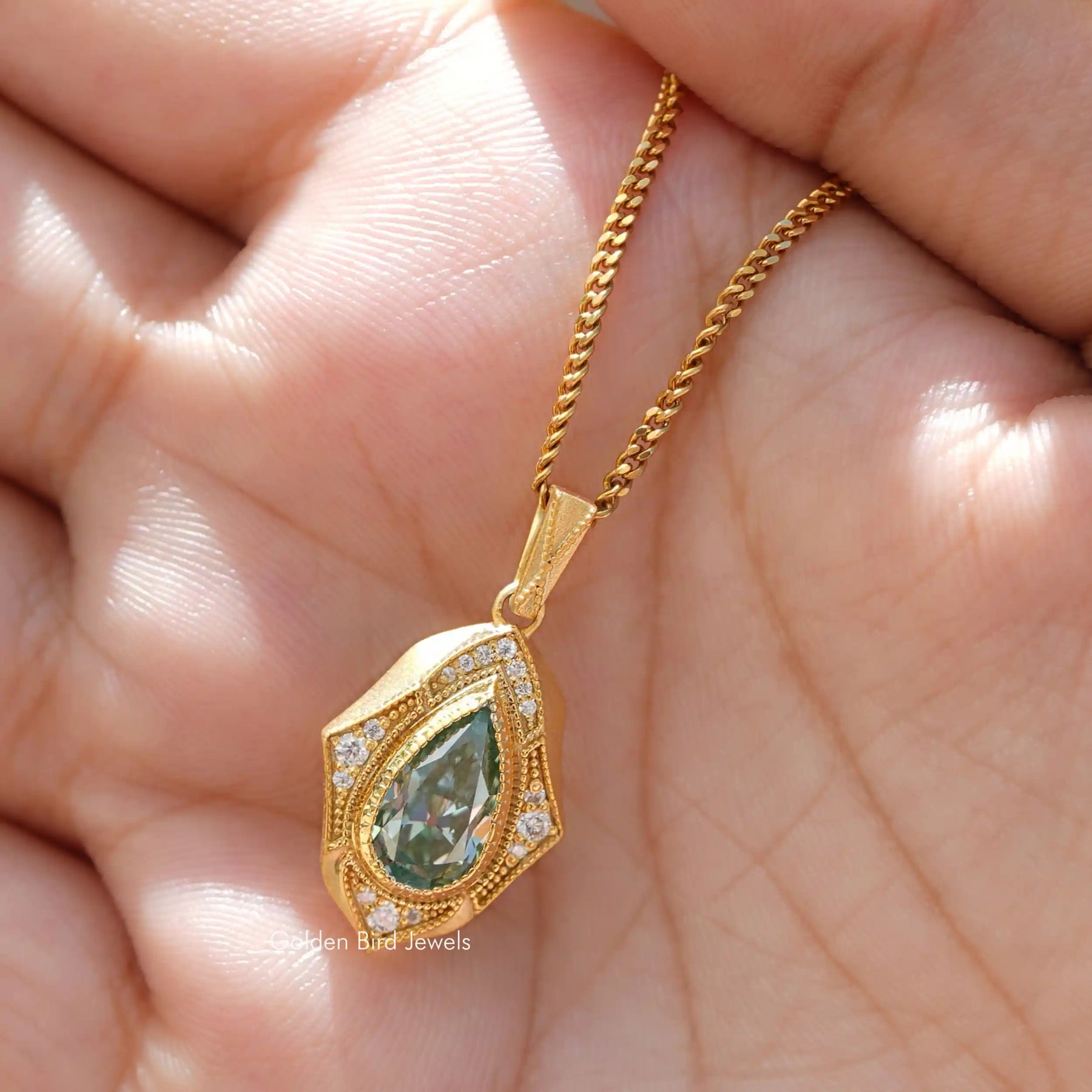 Holding hand view of pear shaped moissanite pendant