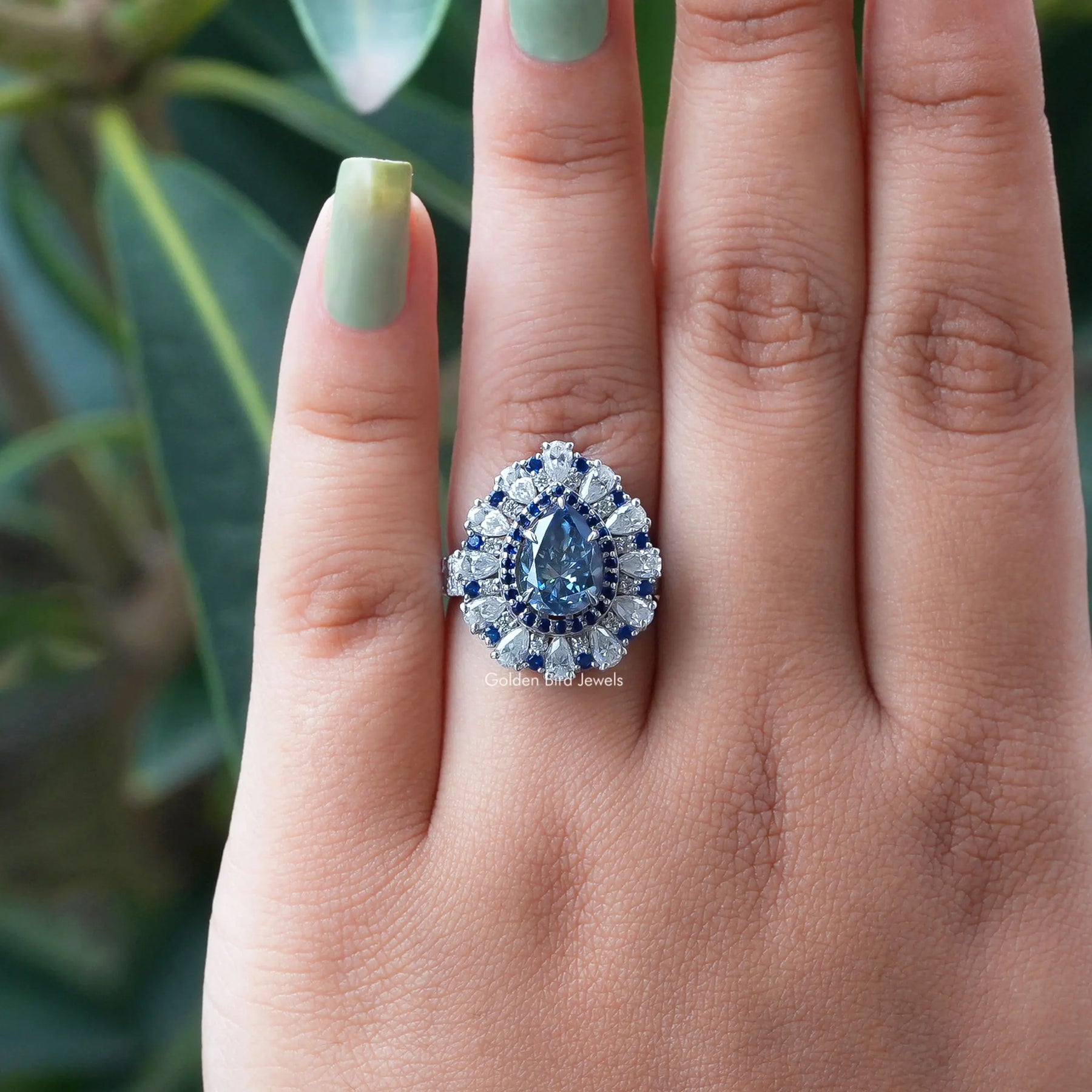 Close-Up View of Blue Pear Cut Halo Moissanite Engagement Ring In White Gold