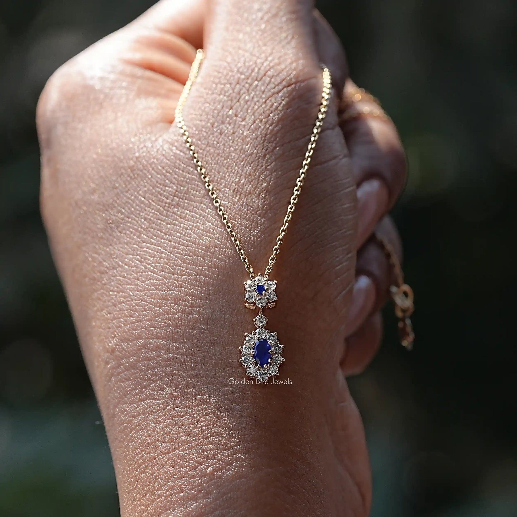View of Blue Sapphire Oval Gemstone Halo Pendant in wear an hand