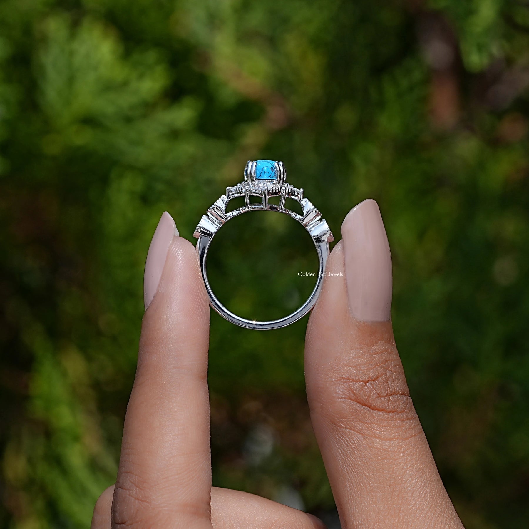 Back View of Pear Cut Gemstone Accent Ring In two fingers