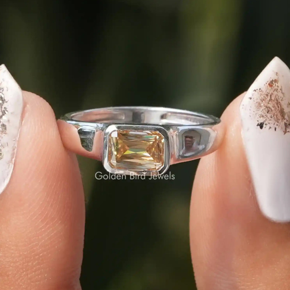 Two fingers holding the Champagne Criss Cut Moissanite Solitaire Ring