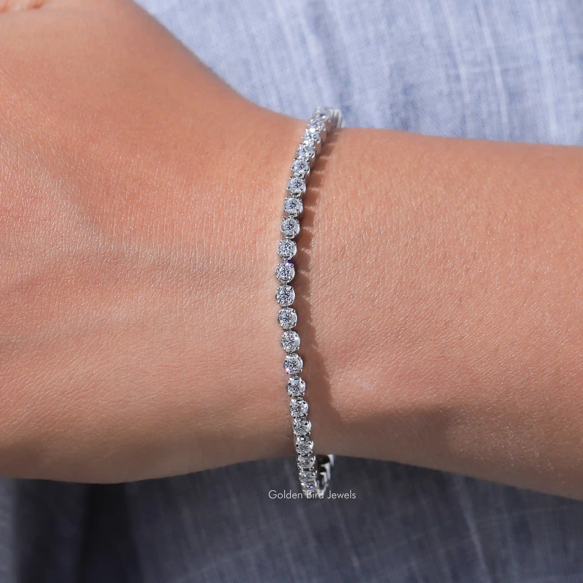 In hand view of round cut moissanite halo bracelet