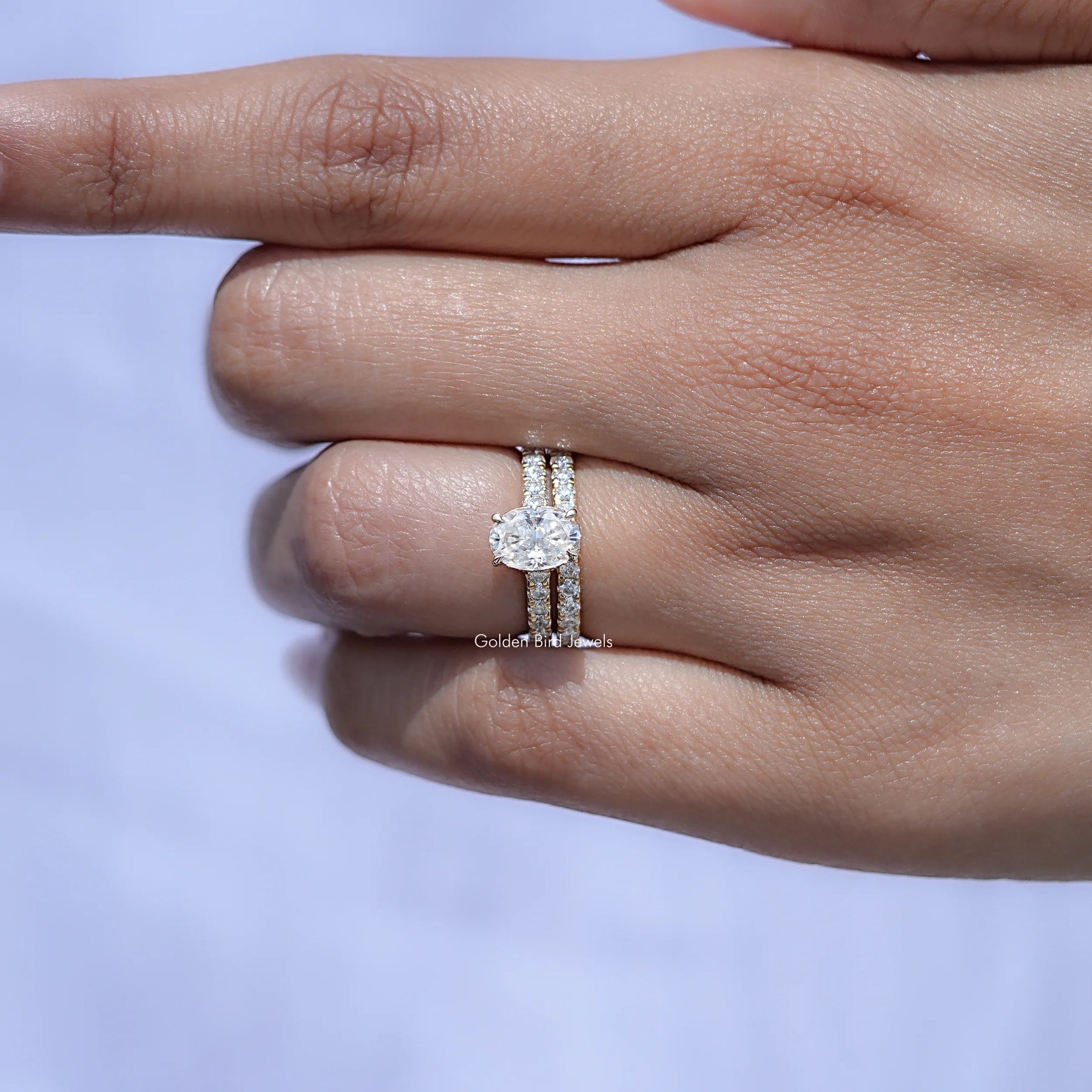 In finger front view of Oval shape moissanite wedding ring in unique shaped