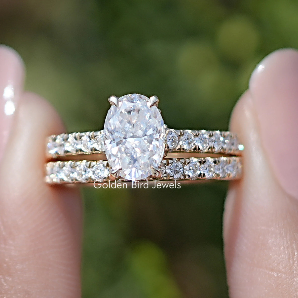 Front view of Crushed Ice Oval Cut Moissanite Wedding Ring Set in two fingers