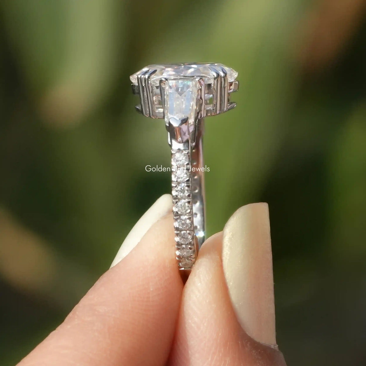 Side View of Ice Oval And Bullet Cut Moissanite Ring In two fingers