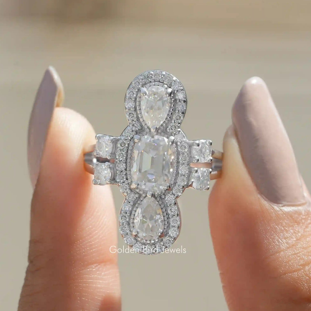 Front View of Old Mine Cushion And Pear Halo Moissanite Ring In two Fingers