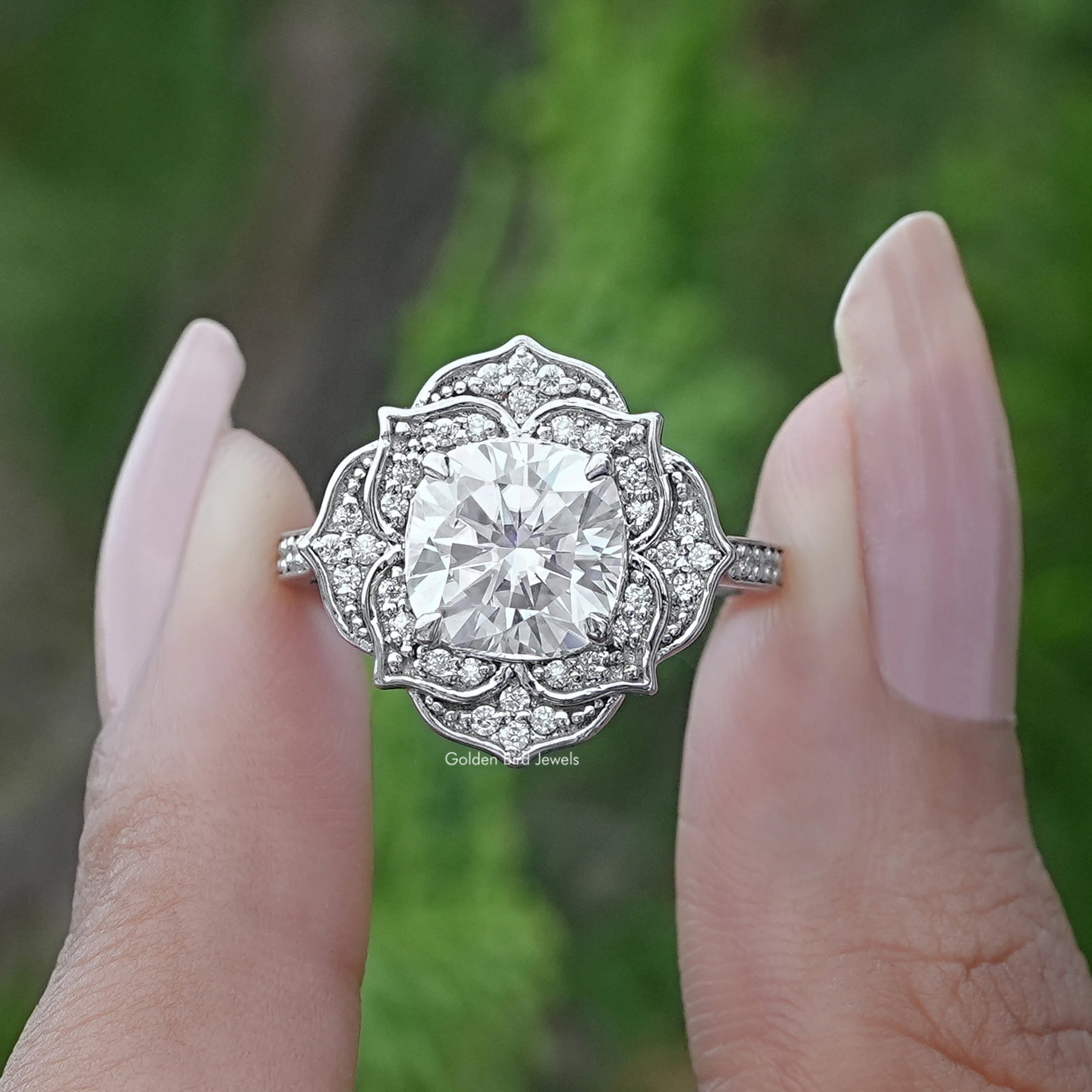 Two fingers holding the Cushion Cut Moissanite Halo Wedding Ring