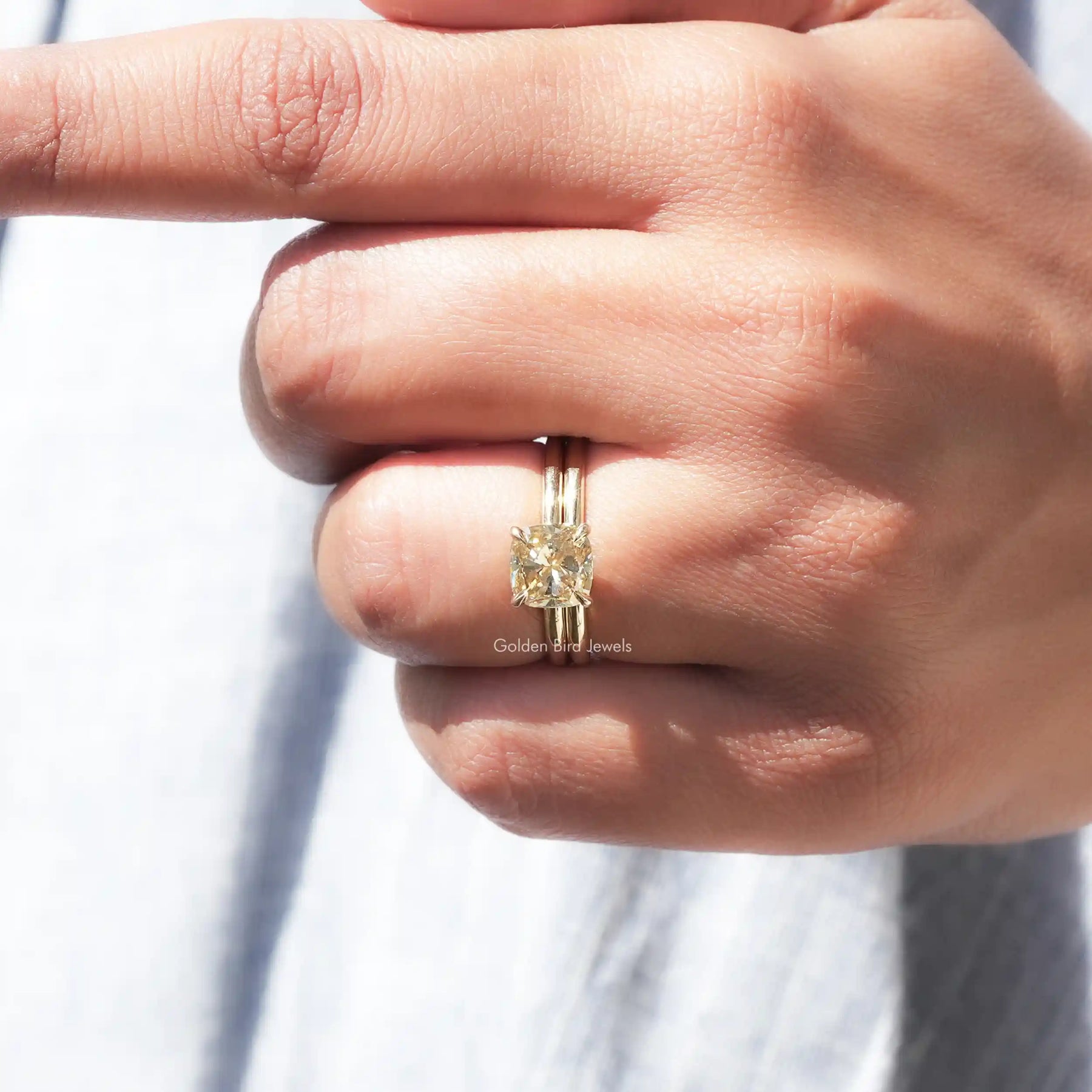 Close view of Solitaire cushion moissanite ring in yellow gold