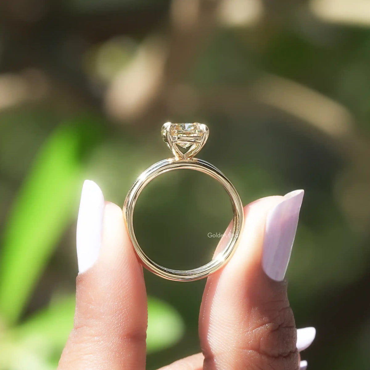 Back view of cushion cut moissanite  ring on holding two fingers