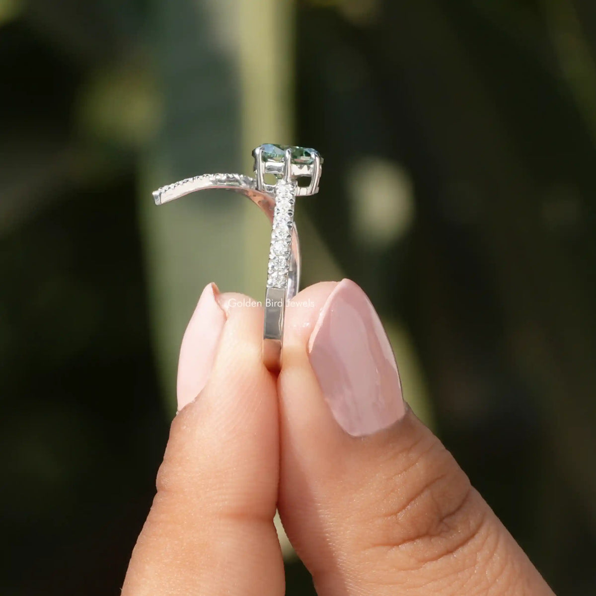 Side View of Oval And Round Cut Moissanite Accent Stone Ring In two fingers
