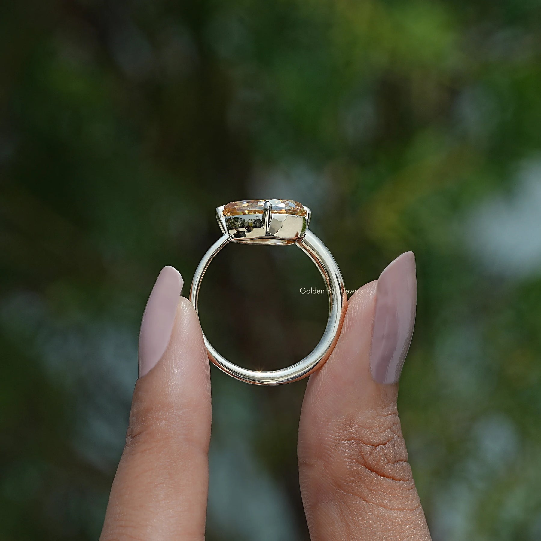 Back View A pear east west engagement ring In two fingers