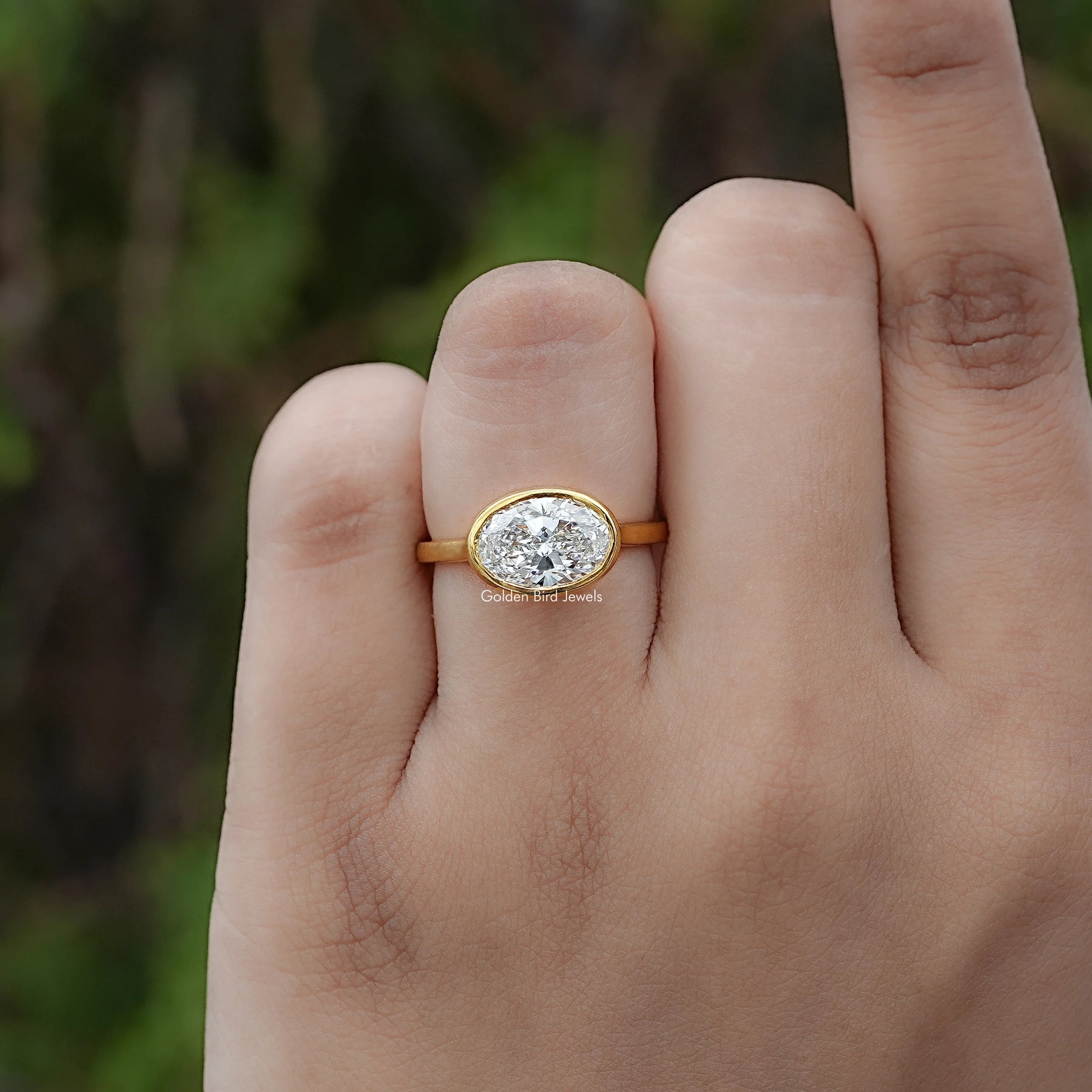 Front view of East West Oval Cut Diamond Bezel Set Ring