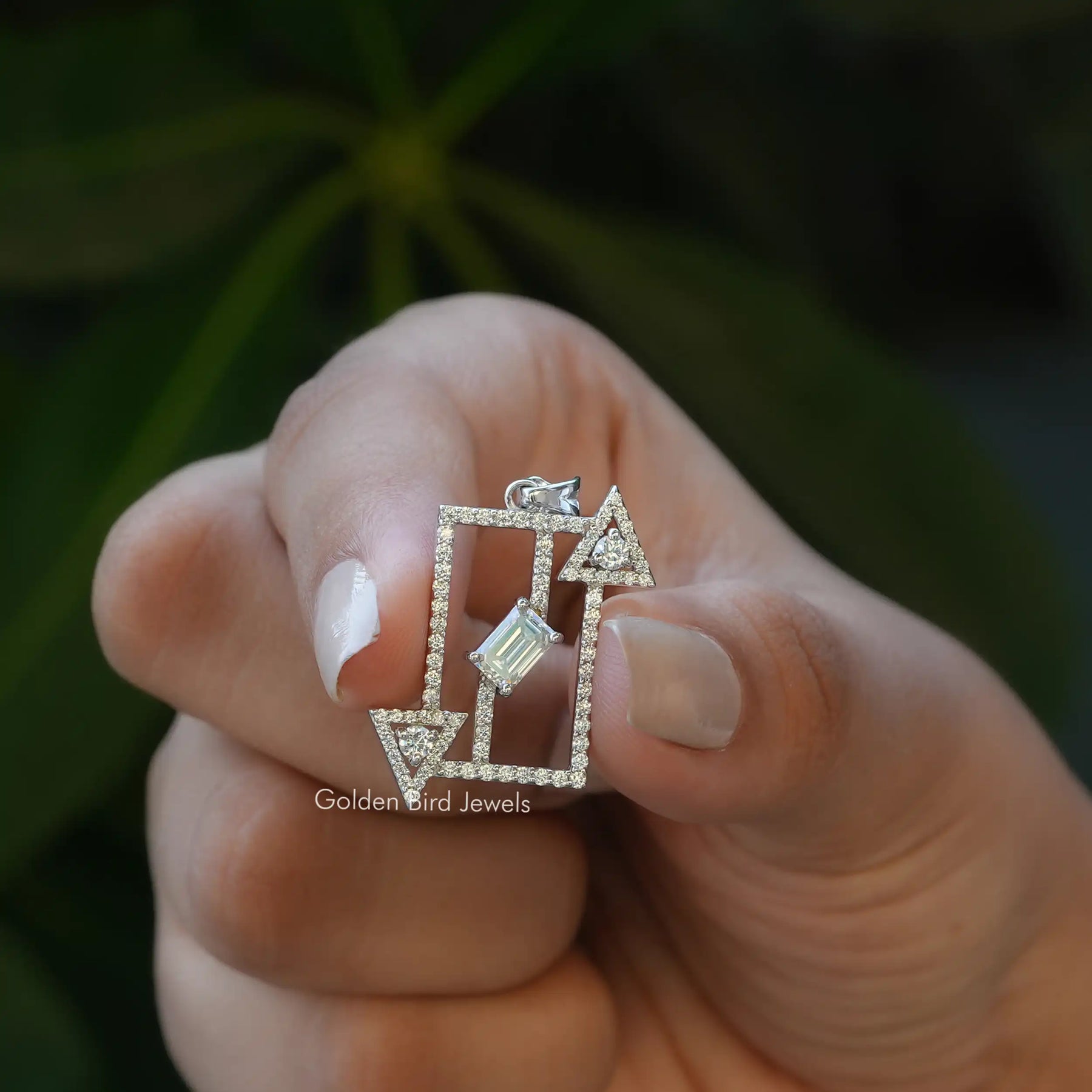 in view of Holding two fingers moissanite emerald pendant