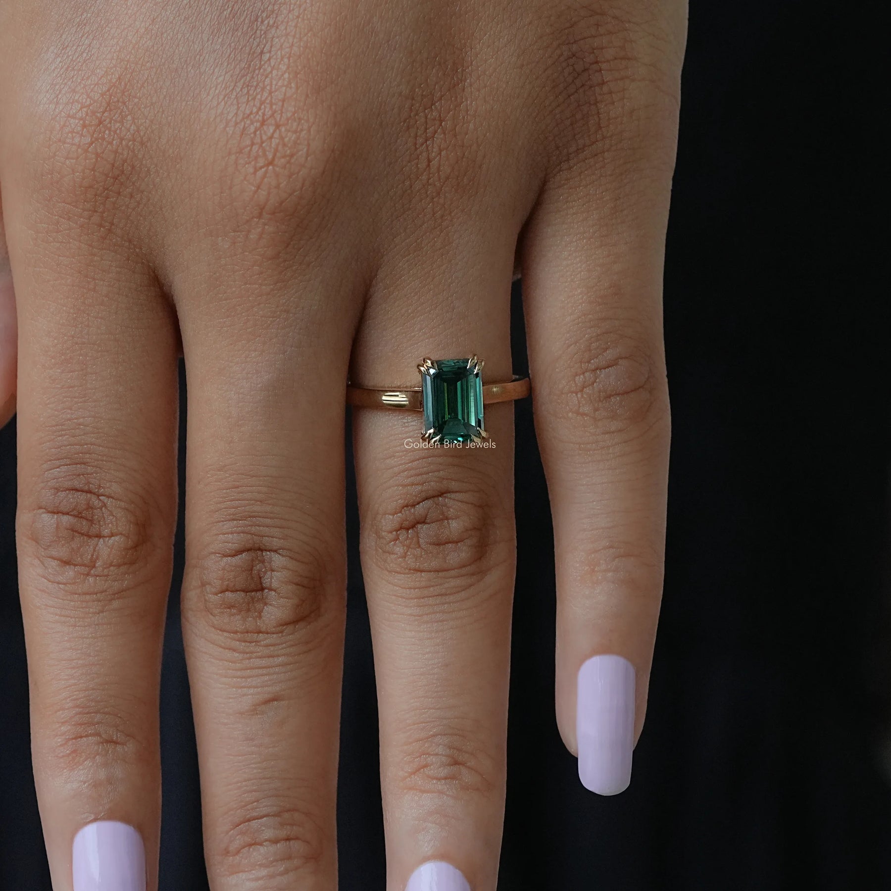 Top View of emerald shape halo engagement ring in green colored