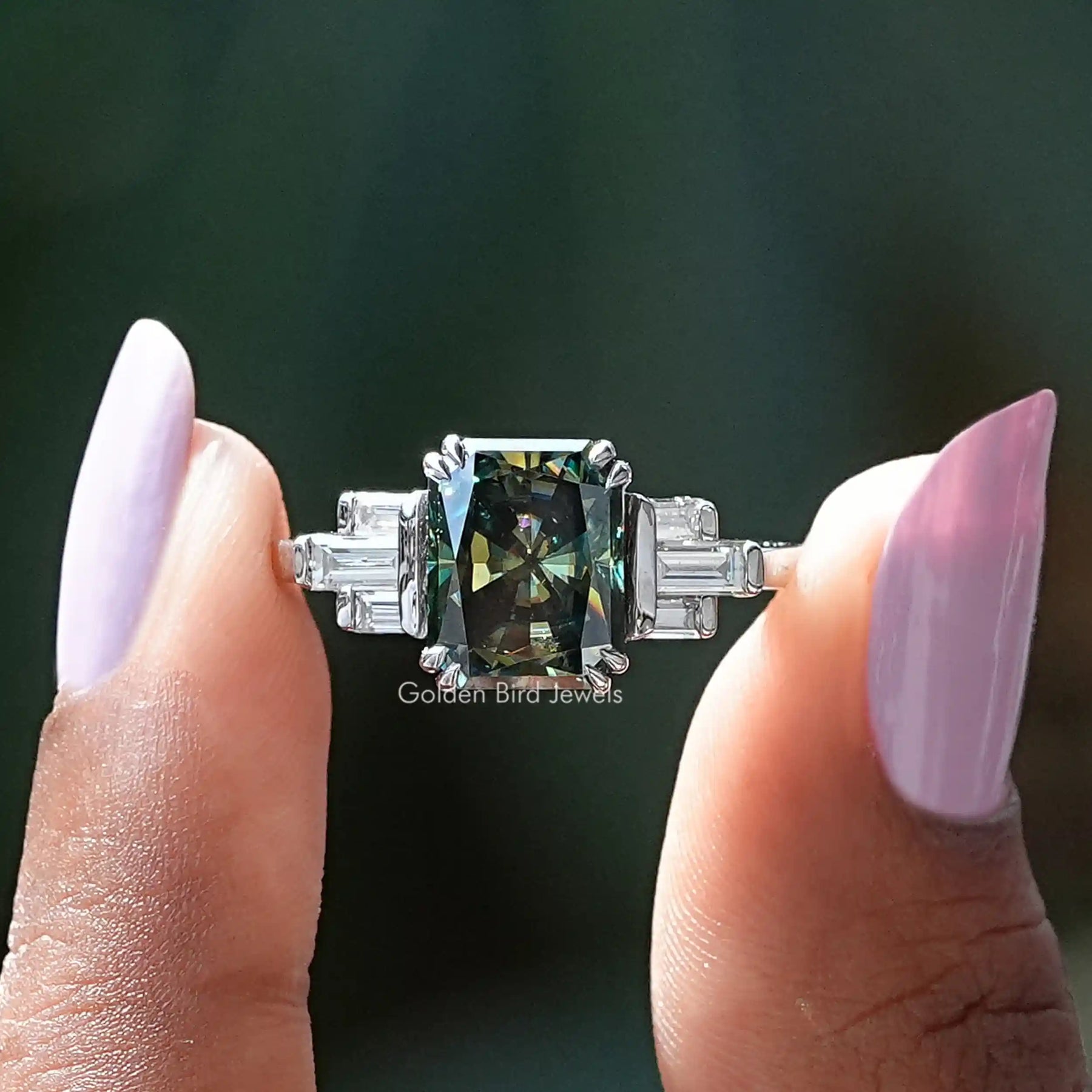 Two fingers holding the Radiant Cut Moissanite Engagement Ring
