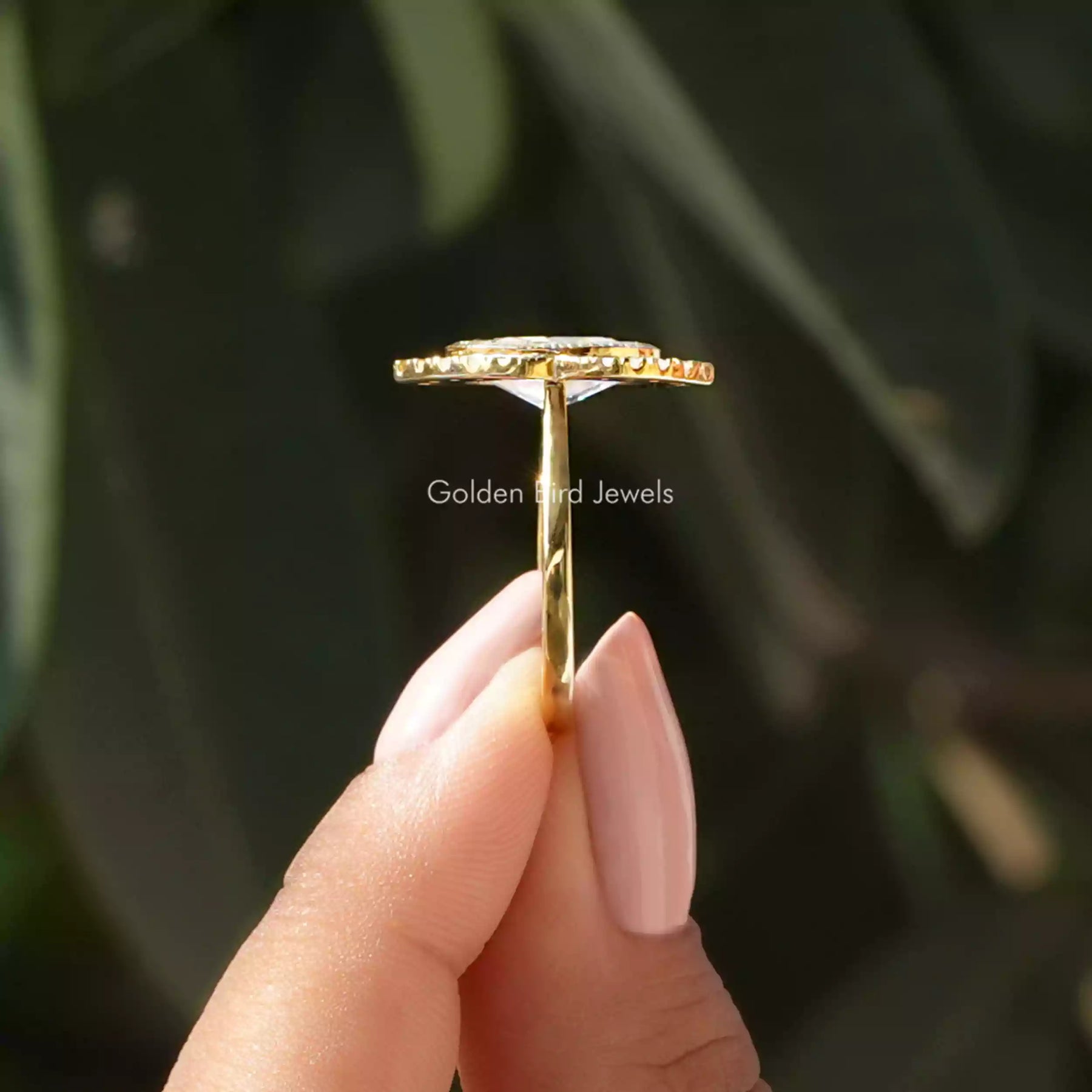 Side View of Ice Oval Cut Halo Engagement Ring In two fingers