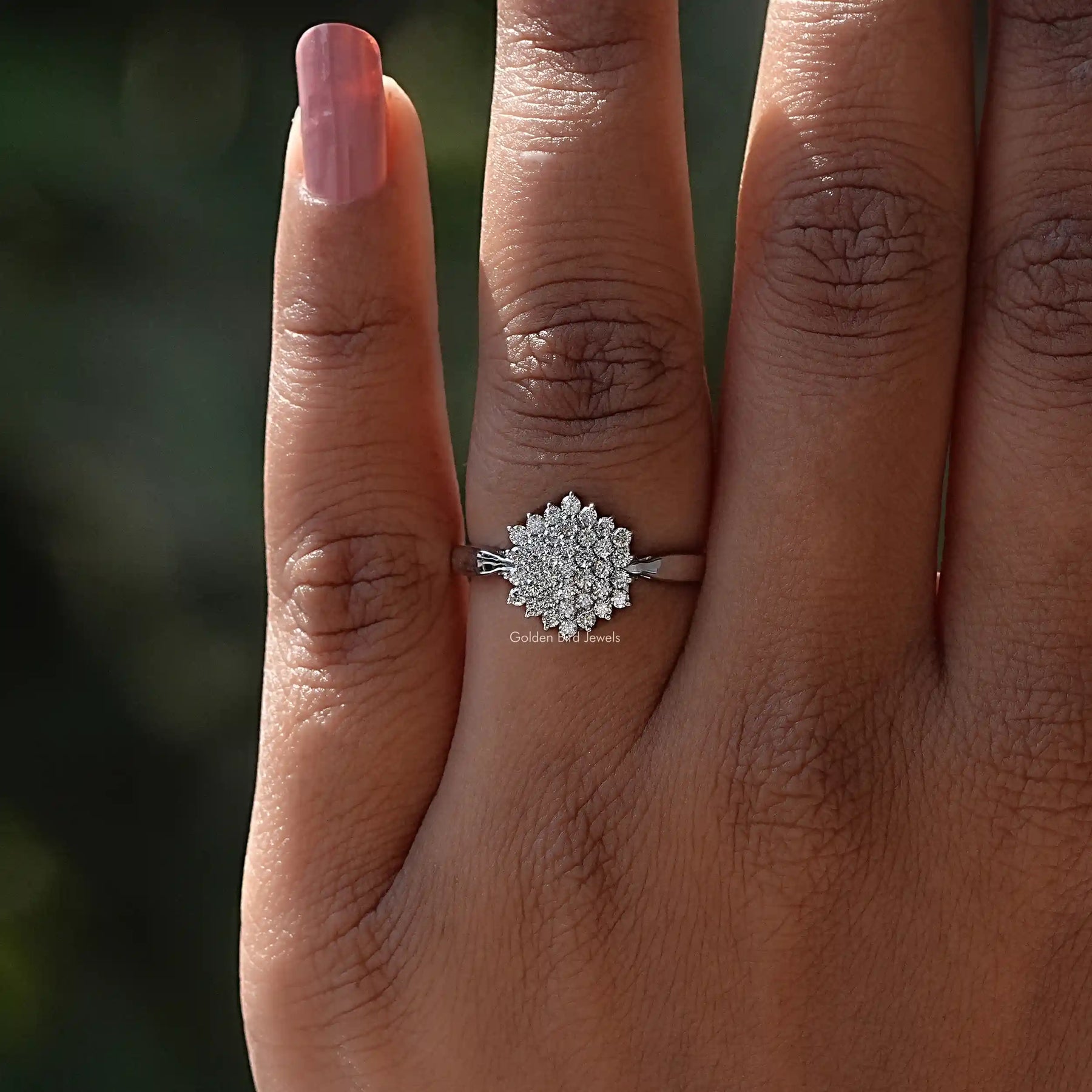White gold ring with round lab-grown diamonds worn on finger.