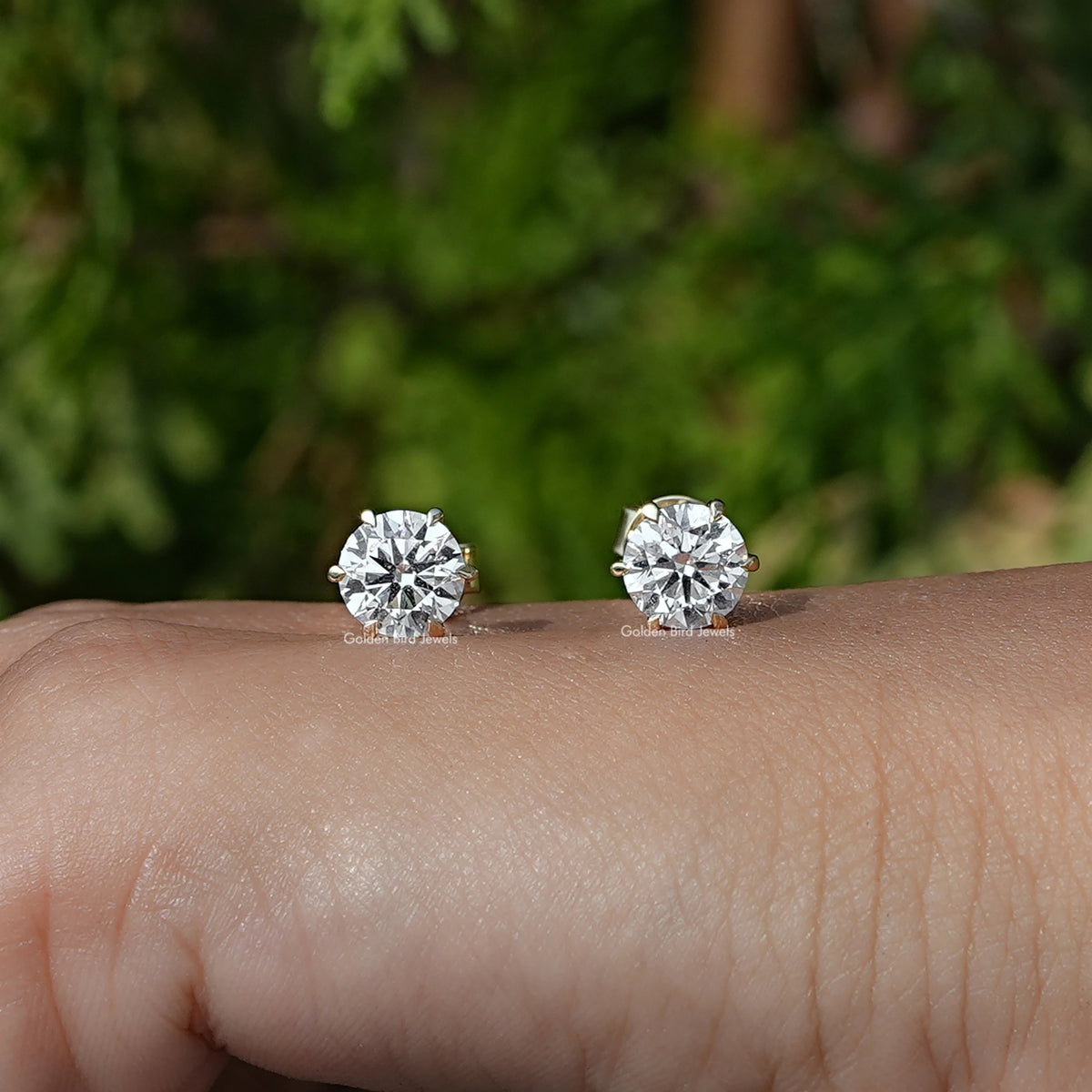 In Hand Front View of Round Cut Solitaire Stud Earrings In White Gold