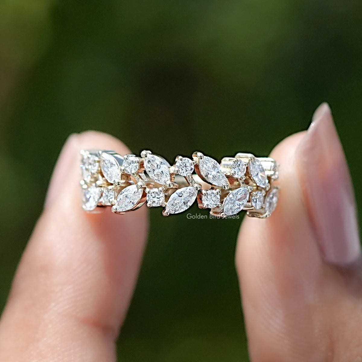 Marquise and Round Cut Lab Diamond Wedding Band Held Between Fingers