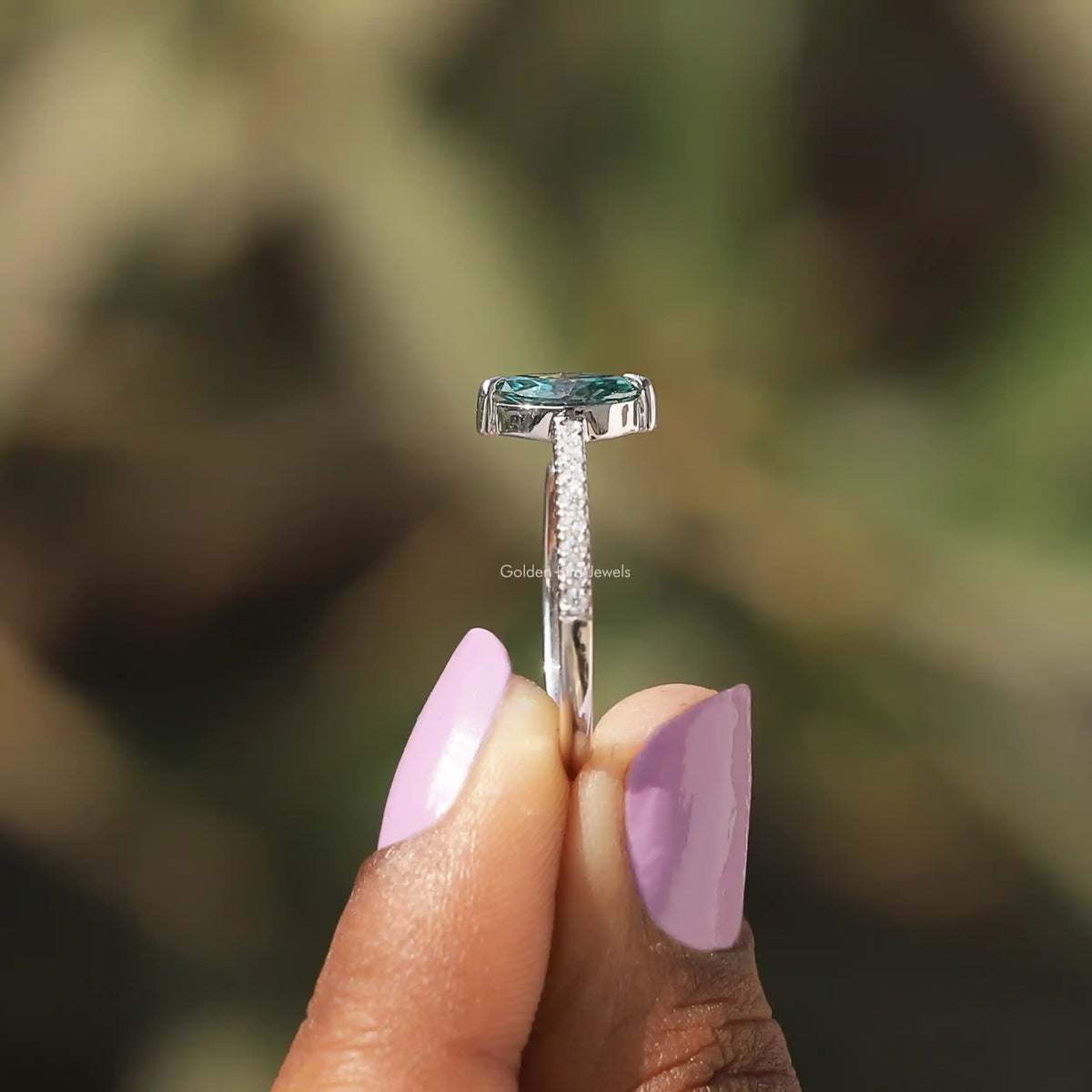 Side View of Moissanite Marquise Cut Accent Stone Ring In two fingers