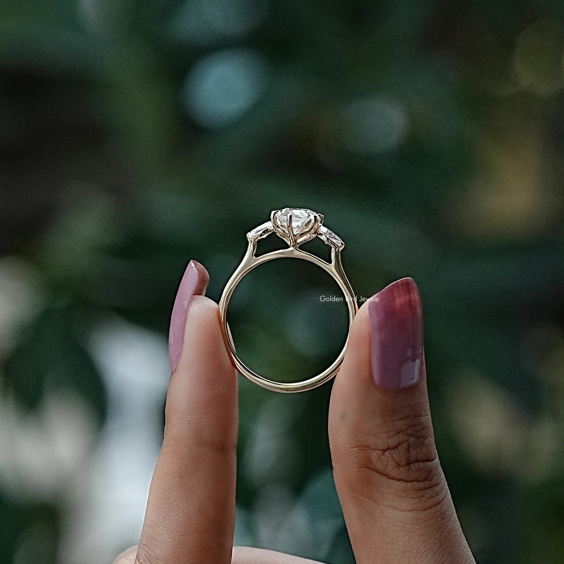 Back View of Marquise Moissanite Three Stone Engagement Ring In two fingers
