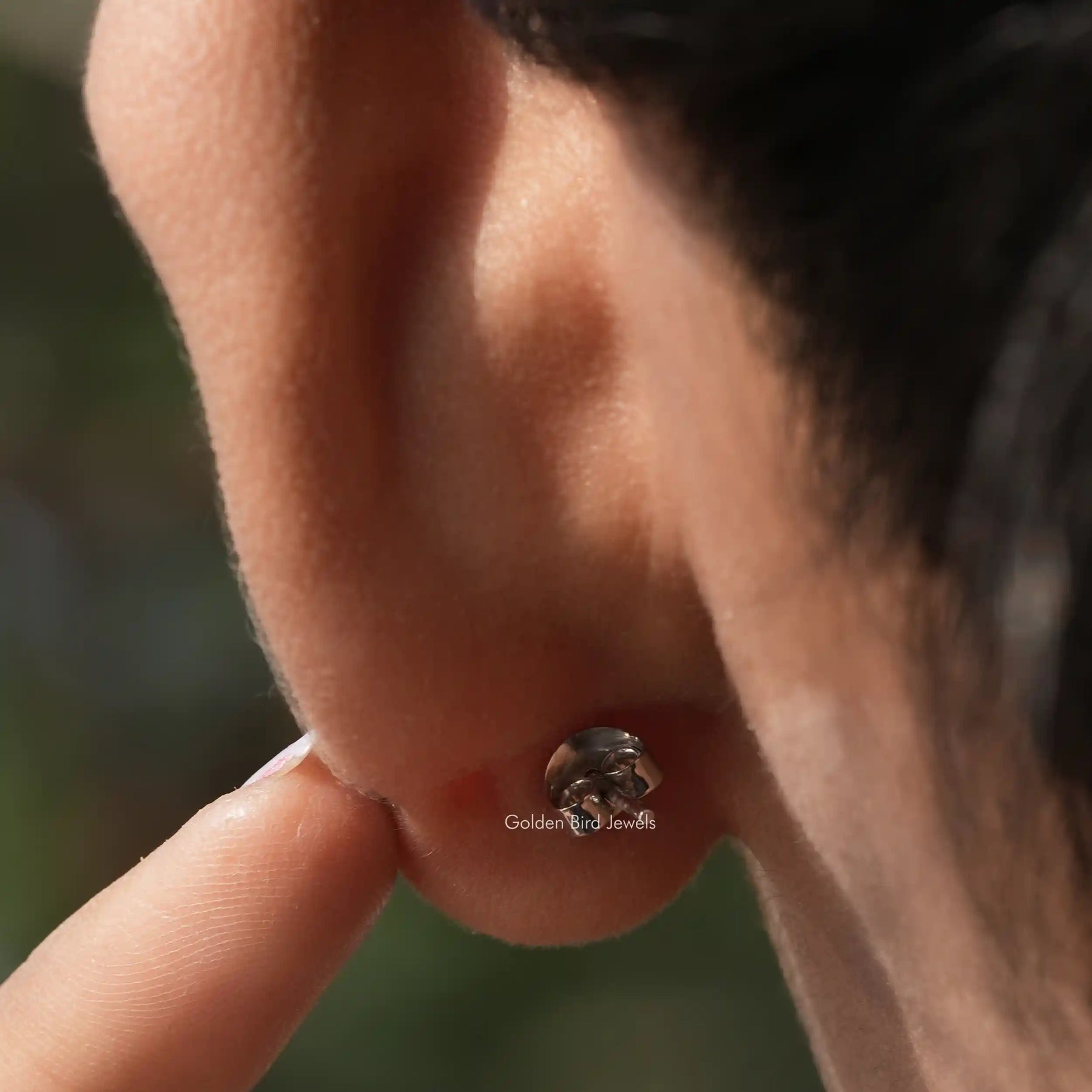 In ear back view of moissanite stud earings in secure setting