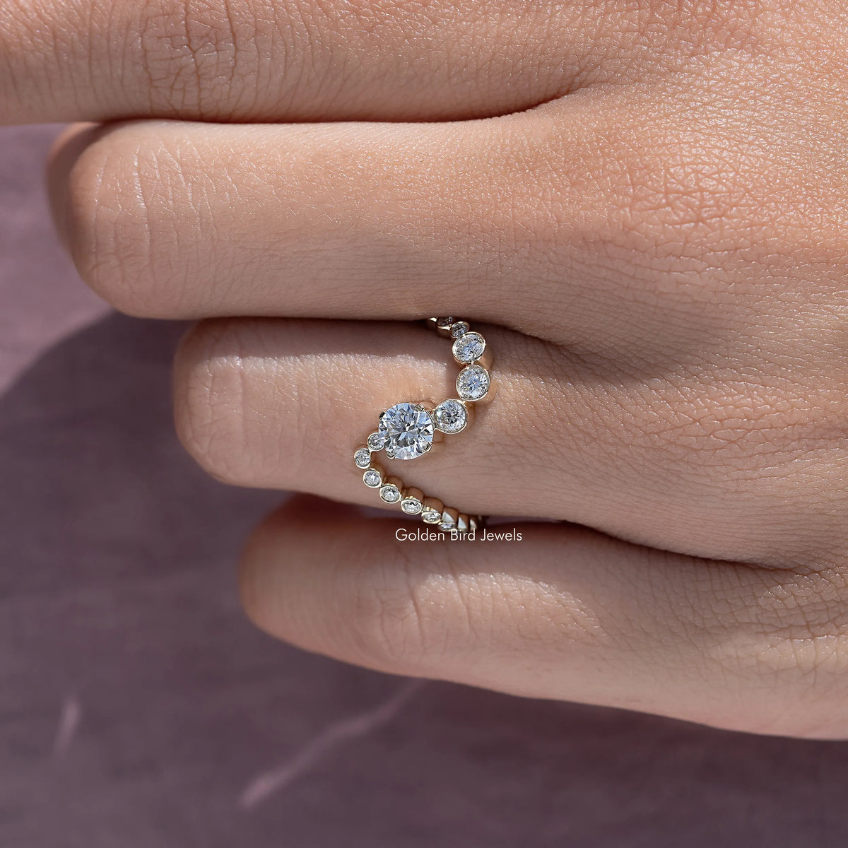 Gold wave wedding band with clustered round stones, close side view on finger