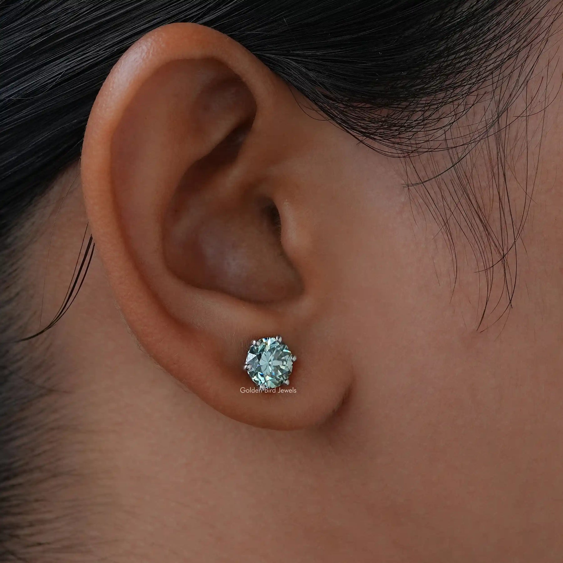 In ear side view of blue, round studs earrings