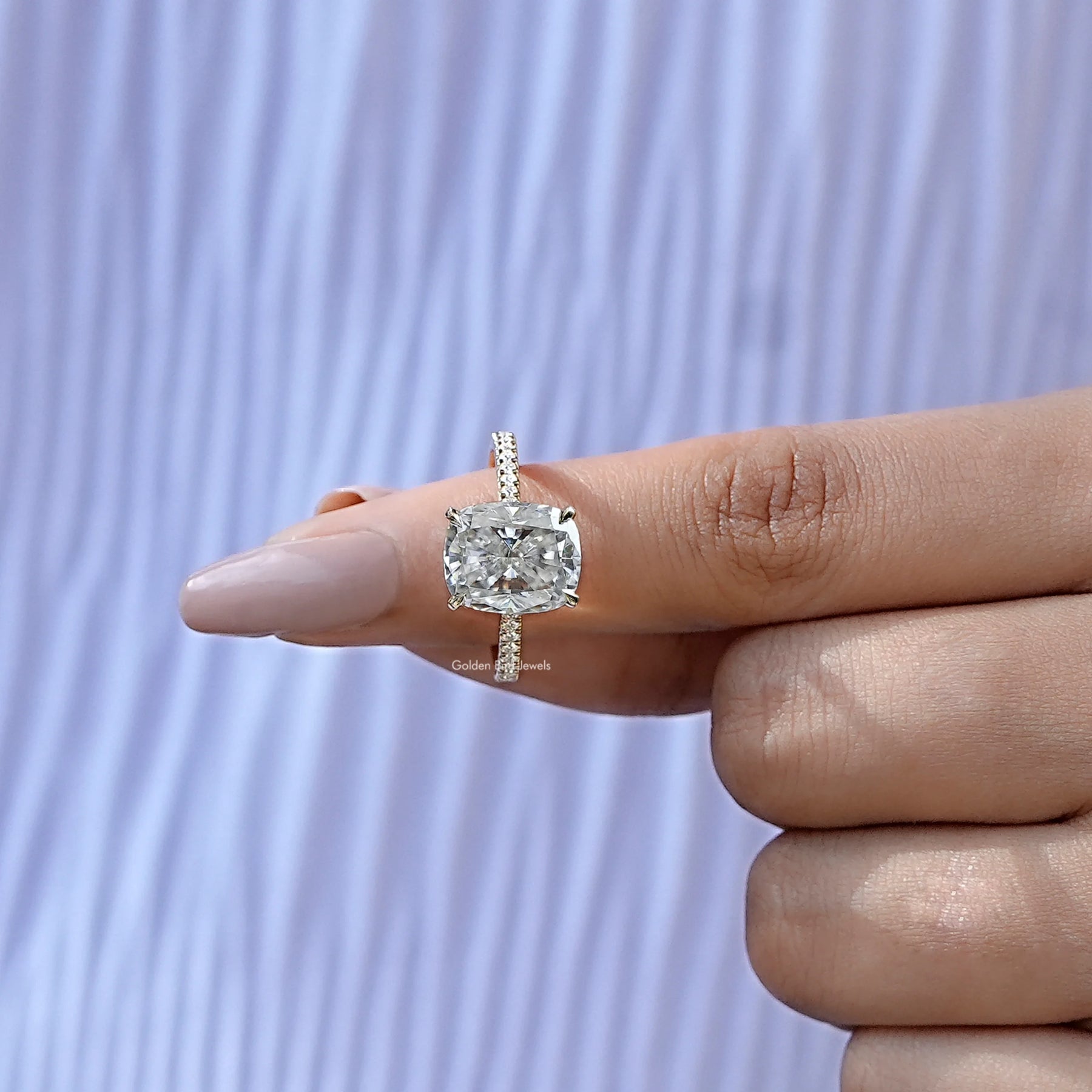 In finger front view of cushion shape moissanite wedding ring in unique shape