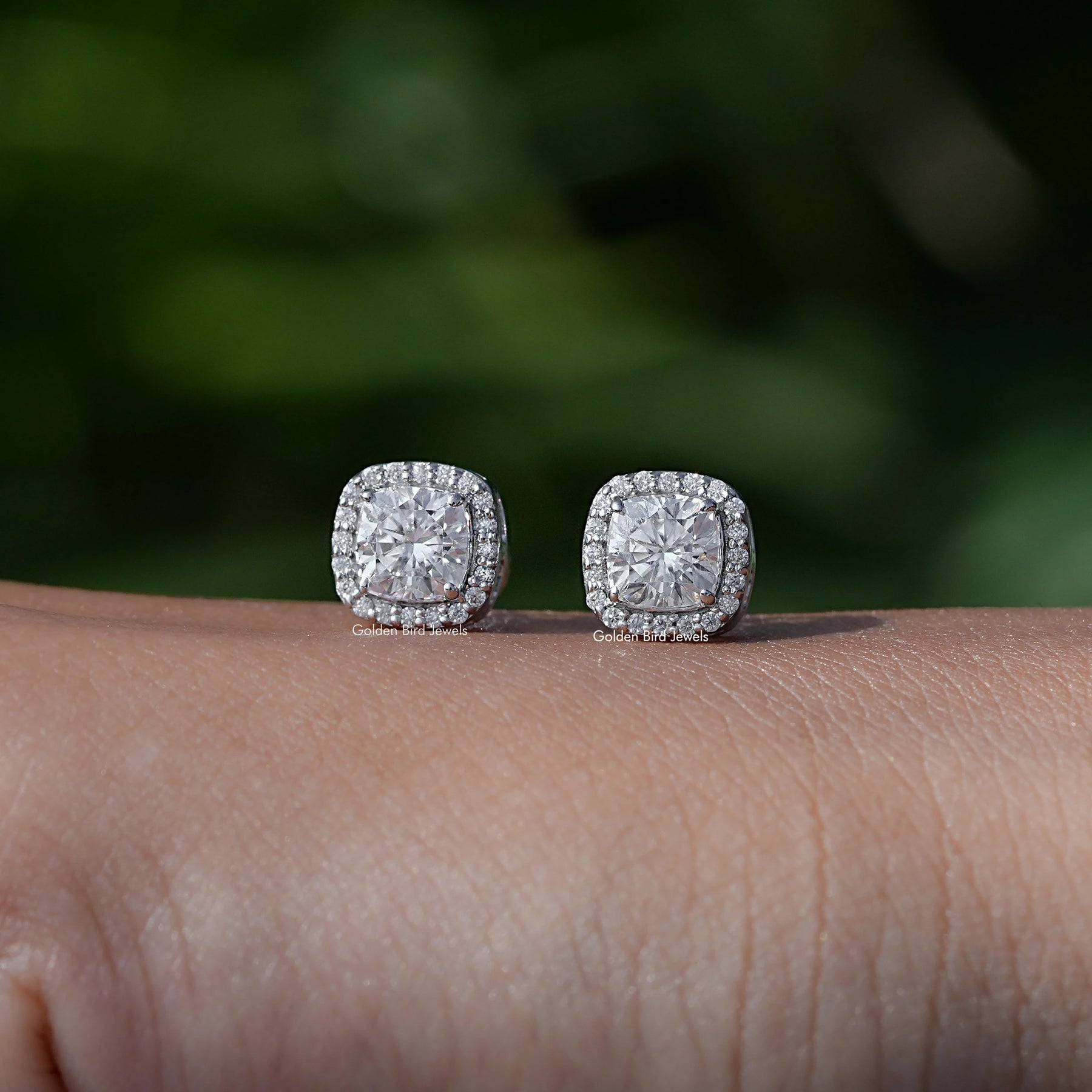 In Hand View Of a cushion cut moissanite stud Earring