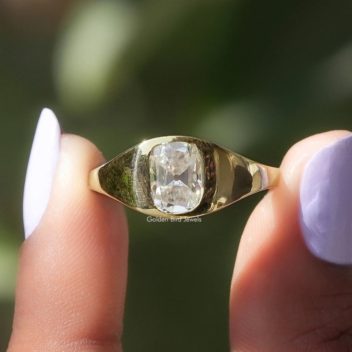 Two fingers holding the Elongated Old Mine Cushion Ring