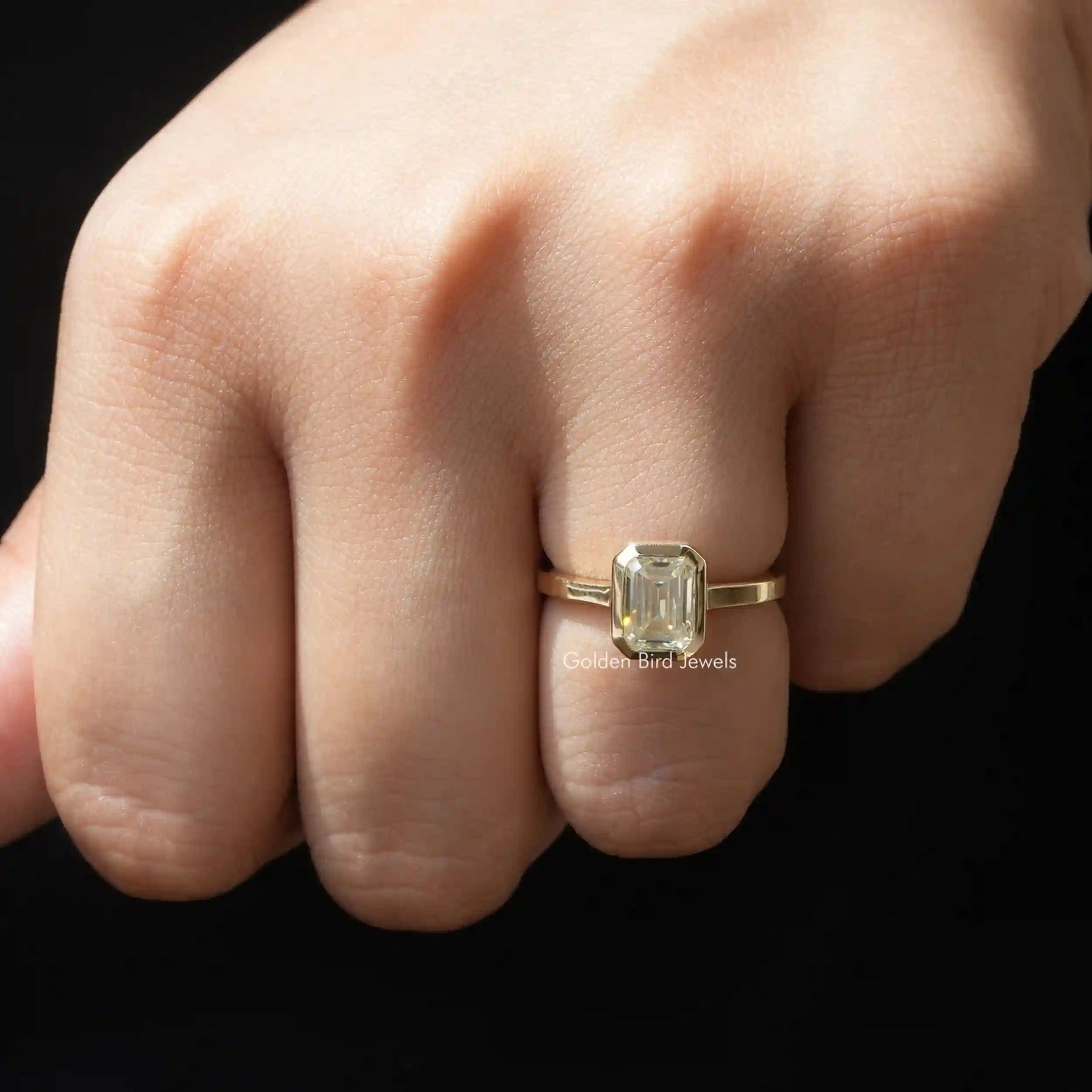 Front view of off white emerald cut solitaire moissanite ring
