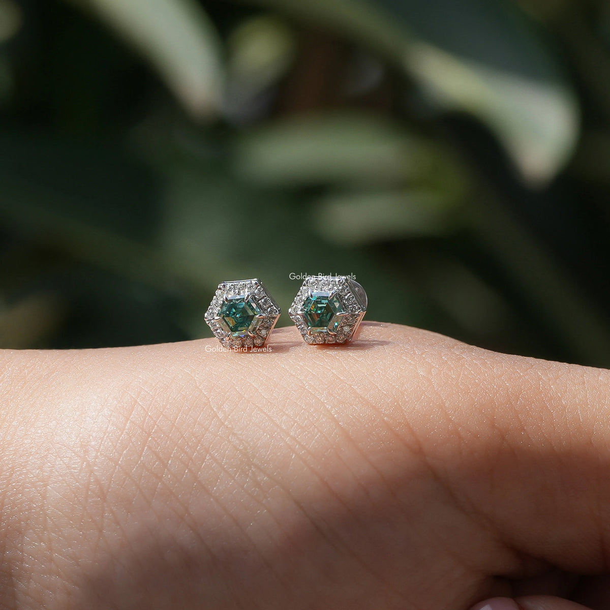 In hand view of hexagon moissanite stud earrings