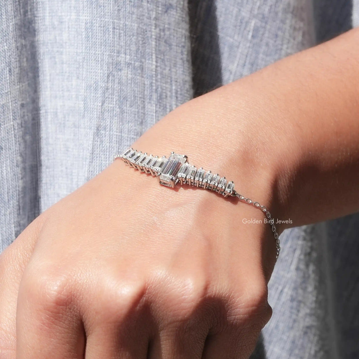 In hand view of round cut and baguette moissanite halo bracelet
