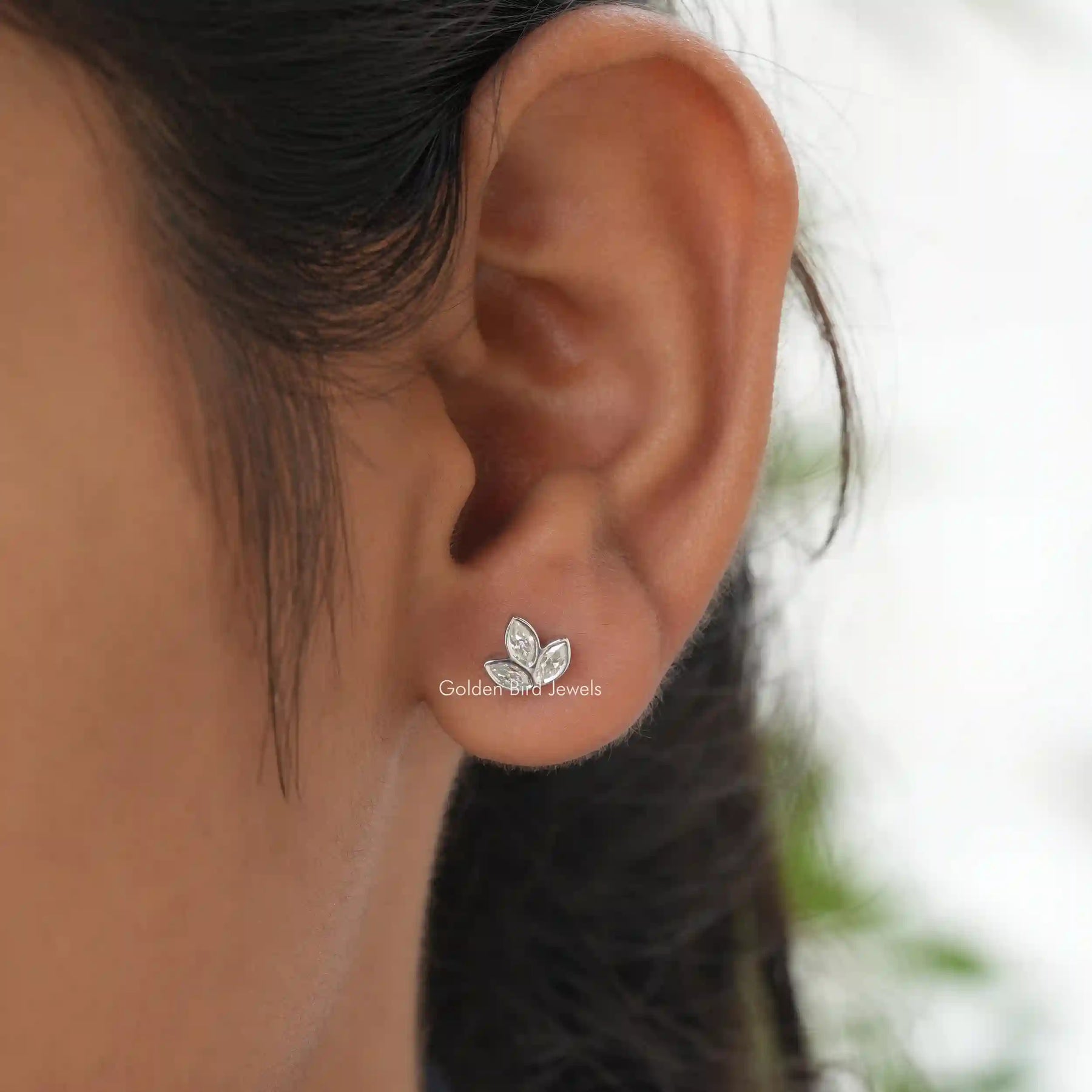 In ear View of colorless marquise cut leaf stud earrings in colorless moissanite