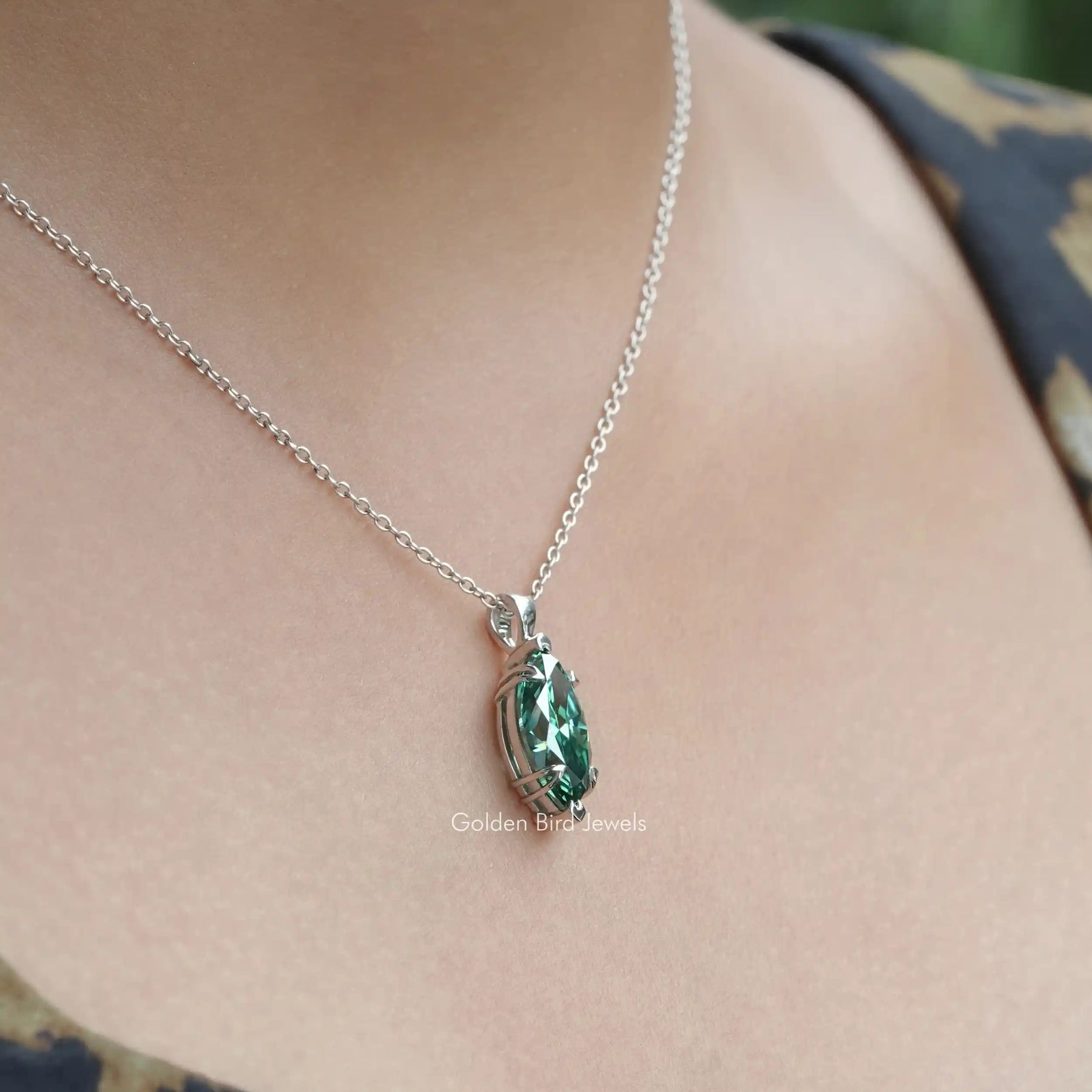 Side view of green marquise pendant In white Gold