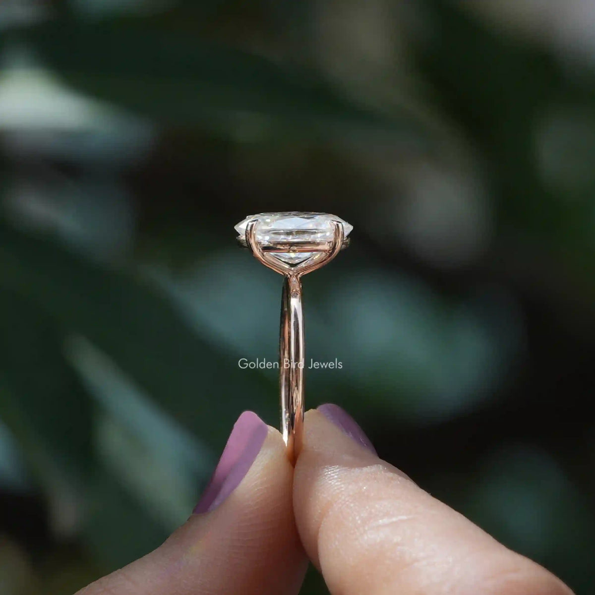 Side View of Solitaire Oval Cut Moissanite Ring In two fingers