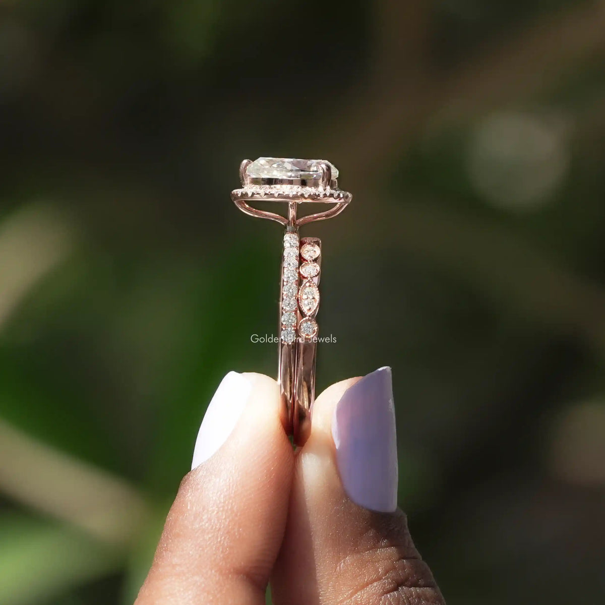 Side View of Pear Cut Moissanite Halo Set Ring In two fingers