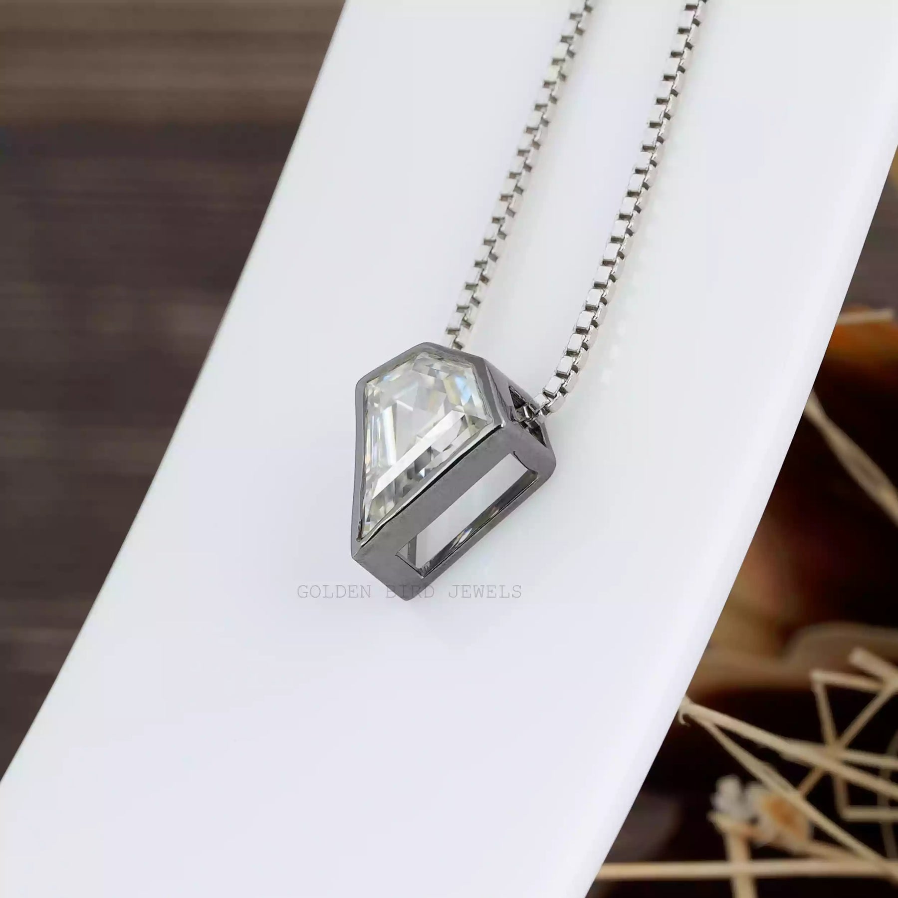 Side view of colorless pentagon cut pendant