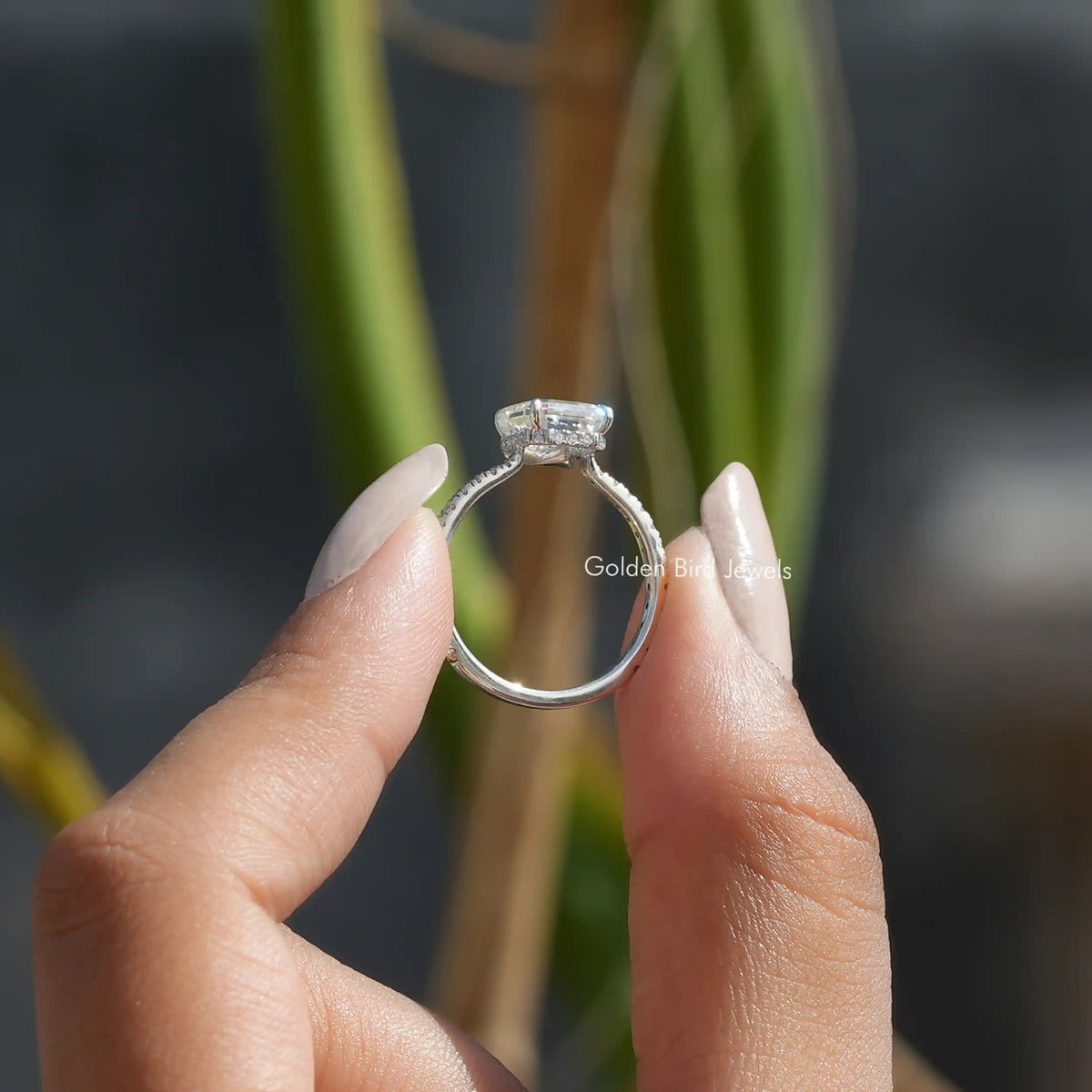 Back View of Moissanite Emerald Cut Engagement Ring In two fingers