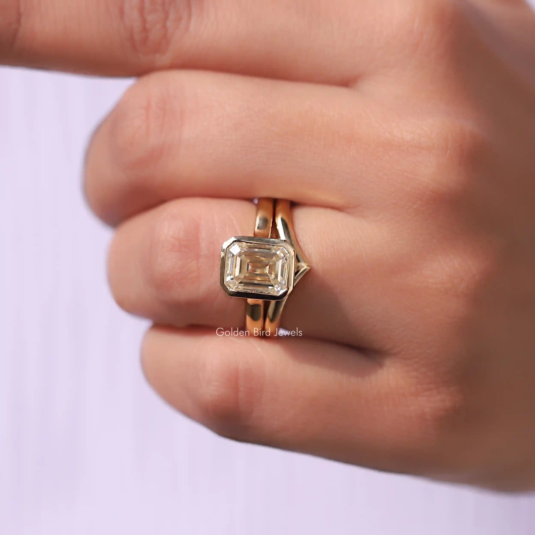 Close-Up View of Moissanite Bezel Set Ring With Curved Band In Yellow Gold