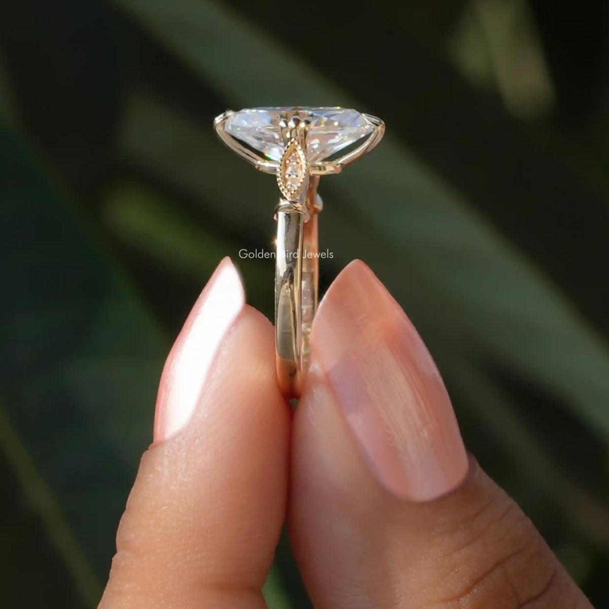 Side View of Moval And Round Cut Moissanite Engagement Ring In two fingers